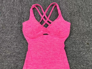 Close-up of rose red yoga bodysuit featuring cross back straps and waist hollow out detail