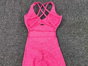 Detail of pink yoga jumpsuit featuring crisscross back straps and ruched butt lifting design