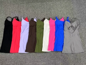 Présentation à plat de robes de yoga dos nu multicolores sur un tapis gris texturé
