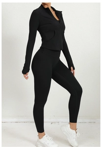 Détail de l'ensemble de sport noir avec veste zippée cintré, passe-pouces et pantalon taille haute