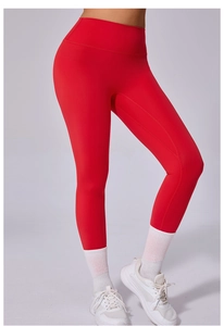 Détail d'un pantalon de yoga rouge à taille haute avec ceinture large et tissu élastique mat