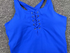 Détail de la combinaison de yoga bleu roi avec dos croisé et œillets de laçage en métal