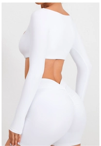 Vista trasera de top de yoga blanco de manga larga y pantalones cortos de fitness