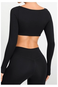 Detalle de conjunto de yoga negro con cintura en V y tejido elástico de alto rendimiento