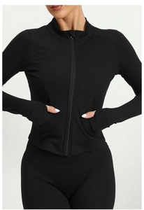 Detailed close-up of slim-fit sports top featuring thumbhole cuffs and stand collar