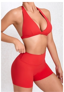 Detail eines roten, schnelltrocknenden Yoga-Sets mit Neckholder-Top und Sport-Shorts