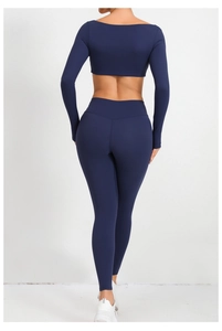 Vista trasera del top corto de manga larga azul marino y los leggings en modelo de fitness