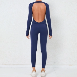 Macro shot of open-back navy yoga bodysuit featuring thumbhole sleeves and stretch fabric