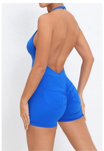 Dettaglio della tuta yoga blu reale con schiena scoperta, tasche push-up e tessuto lucido