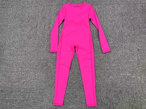 Detailed flat lay of bright pink long sleeve yoga bodysuit on gray textured background