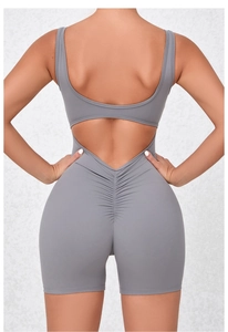 Detail view of the open-back design and ruched lifting seam on the grey yoga bodysuit