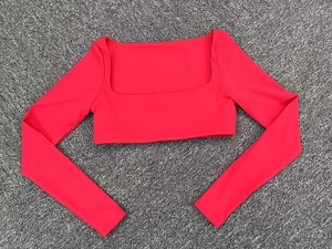 Detalle en plano de top corto rojo con cuello cuadrado y textura de tela elástica suave