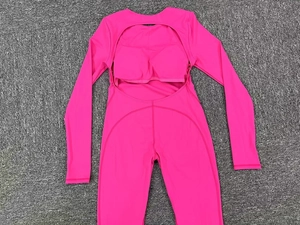 Close-up of rose pink long sleeve backless yoga jumpsuit with cutout detail