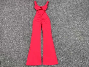 Detail of red hollow-out flared jumpsuit with deep U-neck and waist cutouts