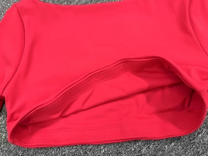 Primer plano detallado del tejido rojo elástico del top de yoga con costuras y textura acanalada