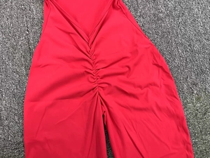 Detailed macro view of the red ruched seam on elastic high-waisted yoga bodysuit