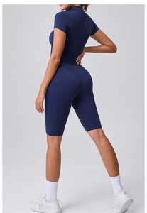 Side view of navy blue short sleeve yoga bodysuit with zipper and contouring fit