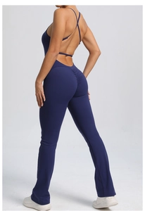 Macro detail of navy blue cross back straps and peach lift design on the yoga jumpsuit
