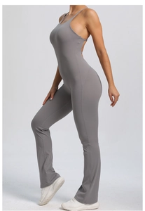 Detail view of grey backless yoga jumpsuit with adjustable straps and flared leg slits