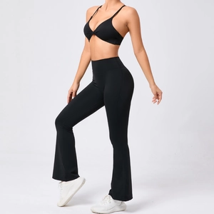 Détail d'un ensemble de yoga noir avec brassière torsadée et legging évasé taille haute