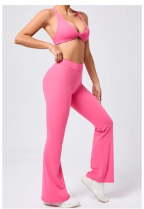Dettaglio dei leggings a zampa a vita alta e reggiseno sportivo con nodo in rosa vivace