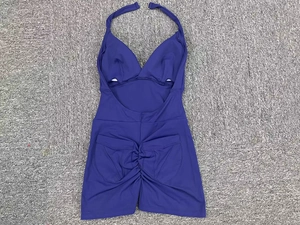 Dettaglio in piano del body blu scuro a lupetto con design arricciato sui glutei