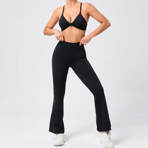 Détail de l'ensemble de sport noir avec brassière torsadée et pantalon de yoga évasé