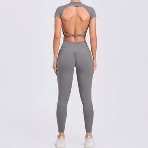 Détail d'un ensemble de yoga gris avec dos ouvert croisé et legging effet push-up