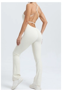 Detail of cross back straps and flared hem on an ivory white yoga fitness jumpsuit