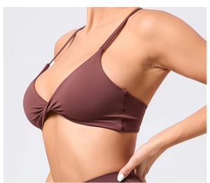 Détail d'un soutien-gorge de sport marron avec un nœud frontal et de fines bretelles réglables