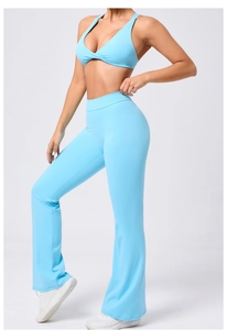 Dettaglio del set yoga azzurro con reggiseno sportivo incrociato e pantaloni a zampa