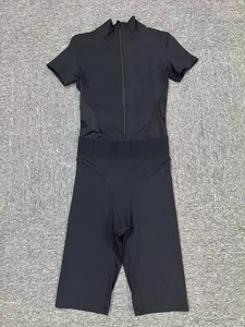 Close-up of black short sleeve yoga bodysuit with zipper and breathable mesh panels