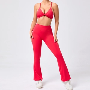 Détail de la brassière rouge torsadée et du legging de yoga évasé à taille haute