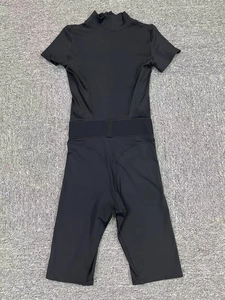 Detailed flat lay of black short sleeve yoga bodysuit with mesh panels and cinched waist