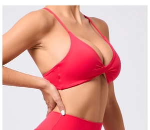 Détail d'une brassière de sport rouge à fines bretelles et nœud torsadé à l'avant