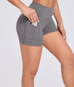 Detail of high-waisted yoga shorts featuring functional side pocket for smartphone storage