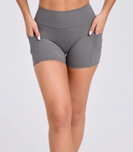 Detail of high-waisted grey yoga shorts featuring side pockets and elastic fabric