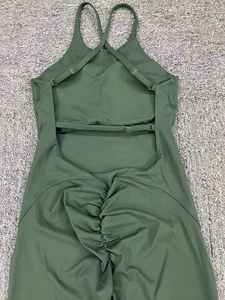 Detail of adjustable cross straps and open back design on green yoga bodysuit