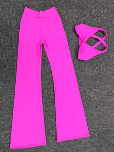 Completo yoga fucsia con pantaloni a campana e top a incrocio su tappeto grigio scuro