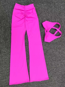 Dettaglio dei pantaloni a zampa a vita alta e top allacciato al collo in fucsia