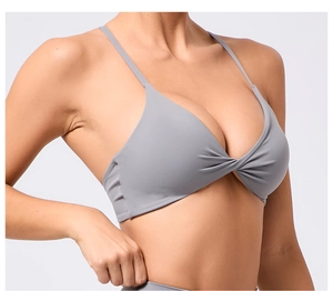 Détail du soutien-gorge de sport gris avec bretelles réglables et nœud torsadé devant
