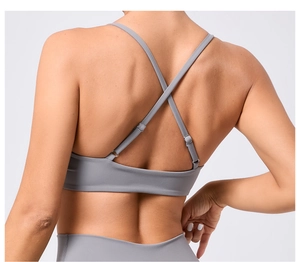 Vue détaillée du soutien-gorge de yoga gris foncé avec bretelles croisées et boucles réglables