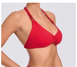 Dettaglio del top bikini rosso allacciato al collo con spalline regolabili e ruches