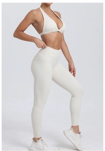 Détail d'un ensemble de yoga blanc cassé avec brassière licou et legging à poches latérales