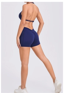 Detail view of navy blue high-waisted yoga shorts with ruched back and side pockets