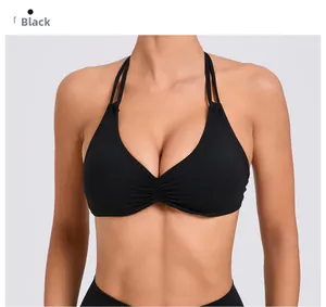 Dettaglio del reggiseno yoga nero con spalline allacciate al collo doppie e design arricciato