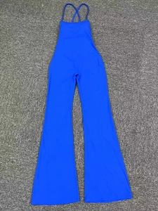 Combinaison de yoga bleu roi avec bretelles croisées et pantalon évasé posée à plat