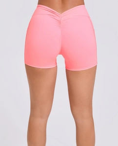 Detail view of pink high-waisted yoga shorts with V-shaped back and scrunch butt lifting design