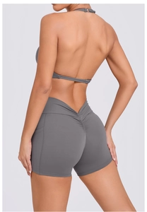 Detail view of grey high-waisted scrunch butt yoga shorts and halter sports bra set
