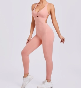Detail view of pink yoga jumpsuit showing back cross straps and hollow waist design